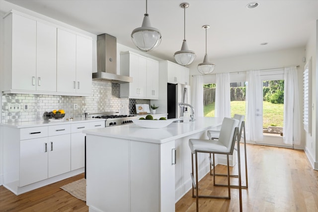 814A Horner Ave, Nashville, TN 37204 - kitchen featuring wall chimney exhaust hood, freestanding refrigerator, decorative backsplash, light countertops, and light wood-style floors