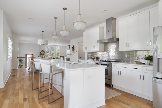 814A Horner Ave, Nashville, TN 37204 - kitchen with wall chimney exhaust hood, stainless steel appliances, a sink, tasteful backsplash, and a kitchen island with sink