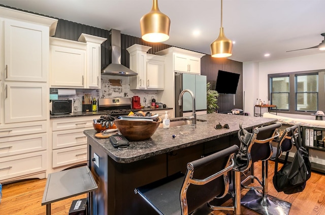 3802B Hutson Ave, Nashville, TN 37216 - kitchen with wall chimney exhaust hood, freestanding refrigerator, a sink, a kitchen bar, and light wood finished floors