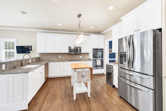 113 Abbeywood Dr, Nashville, TN 37215 - kitchen with appliances with stainless steel finishes, a sink, white cabinetry, wine cooler, and hanging light fixtures