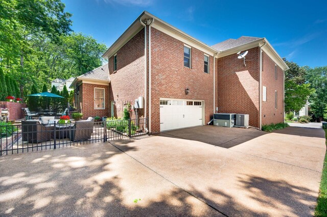 113 Abbeywood Dr, Nashville, TN 37215 - view of home's exterior featuring a garage, driveway, brick siding, fence, and central AC