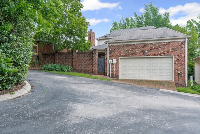 55 Revere Park, Nashville, TN 37205 - view of front facade with driveway, brick siding, a garage, and a chimney
