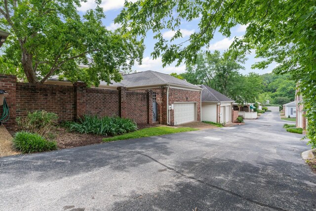 55 Revere Park, Nashville, TN 37205 - view of side of home featuring an attached garage, driveway, and brick siding