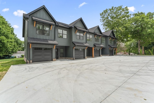 217 S Porter St S Unit 217, Winchester, TN 37398 - view of front of property featuring a garage, board and batten siding, driveway, stone siding, and a shingled roof