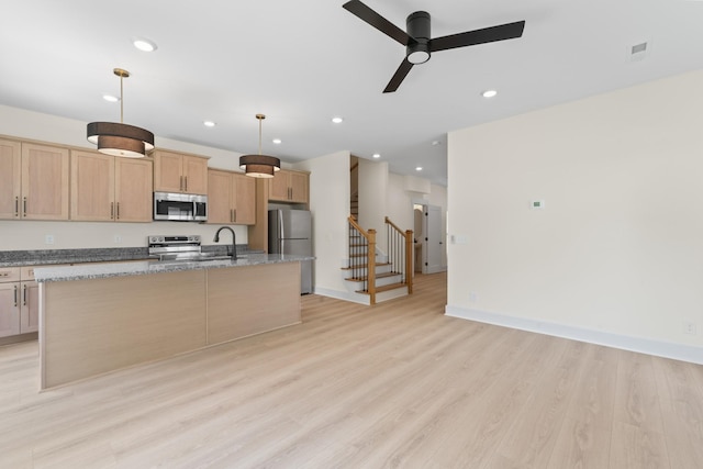 211 Porter St Unit 211, Winchester, TN 37398 - kitchen with appliances with stainless steel finishes, a center island with sink, ceiling fan, light wood finished floors, and light stone countertops
