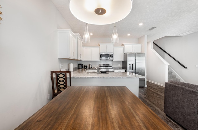1840 Bethpage Dr, Murfreesboro, TN 37127 - kitchen with stainless steel appliances, a sink, a peninsula, white cabinets, and dark wood-style floors
