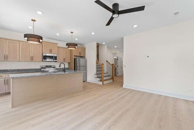 215 S Porter St Unit 215, Winchester, TN 37398 - kitchen featuring appliances with stainless steel finishes, a center island with sink, a ceiling fan, light wood-type flooring, and light stone countertops
