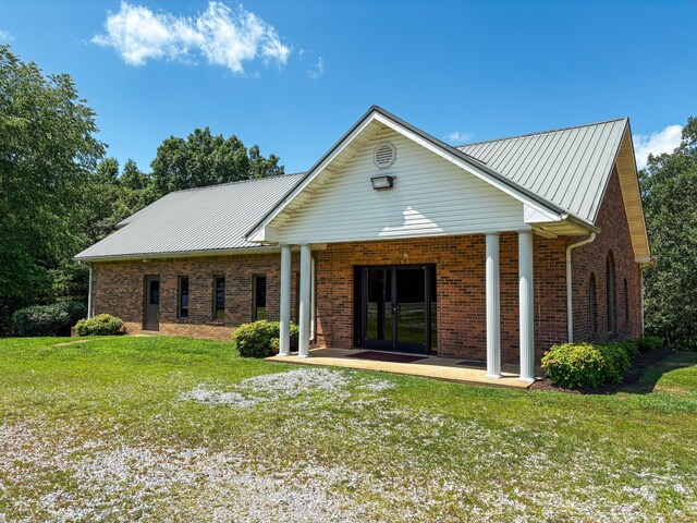 110 Hankins Rd, Hohenwald, TN 38462 - view of front of property with a front lawn, brick siding, and metal roof
