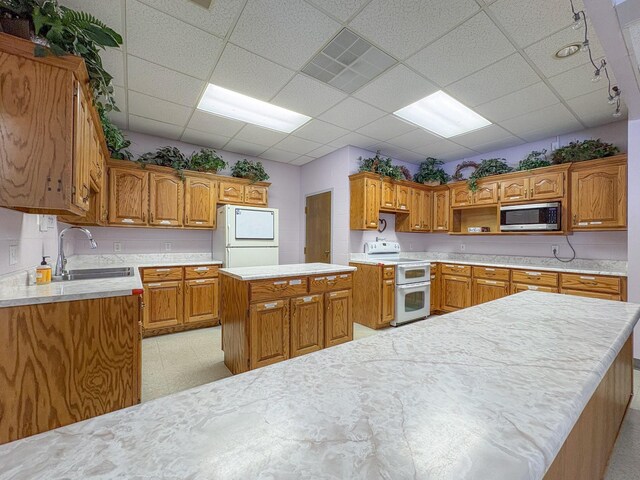 110 Hankins Rd, Hohenwald, TN 38462 - kitchen with white appliances, a sink, a center island, light countertops, and a paneled ceiling