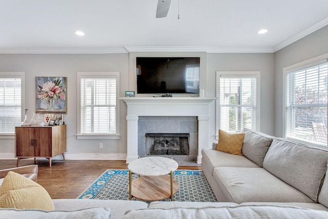 6214A California Ave, Nashville, TN 37209 - living room with ornamental molding, wood finished floors, a tiled fireplace, a ceiling fan, and baseboards