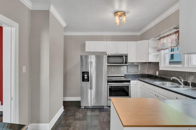 521 E Eastland St, Gallatin, TN 37066 - kitchen with stainless steel appliances, a sink, white cabinets, baseboards, and ornamental molding