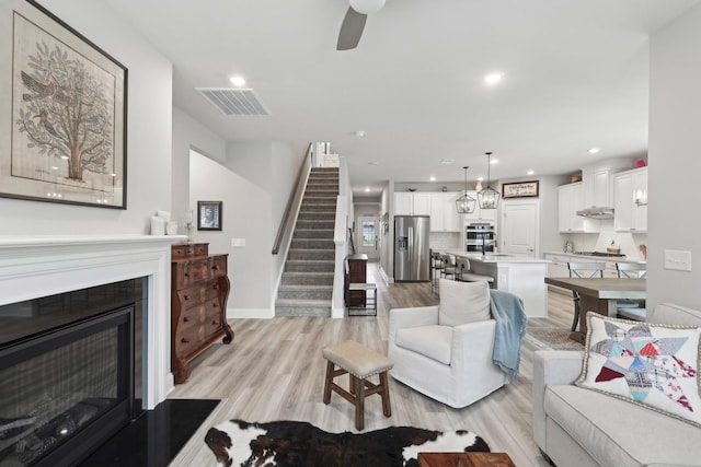 3706 Bonnie Blue Ct, Rockvale, TN 37153 - living room with light wood-type flooring, stairway, a ceiling fan, recessed lighting, and baseboards