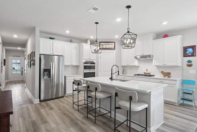 3706 Bonnie Blue Ct, Rockvale, TN 37153 - kitchen with stainless steel appliances, a sink, under cabinet range hood, tasteful backsplash, and light countertops