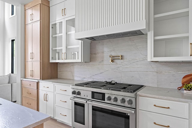 219 Chamberlin St, Nashville, TN 37209 - kitchen featuring range with two ovens, premium range hood, light stone counters, and glass insert cabinets