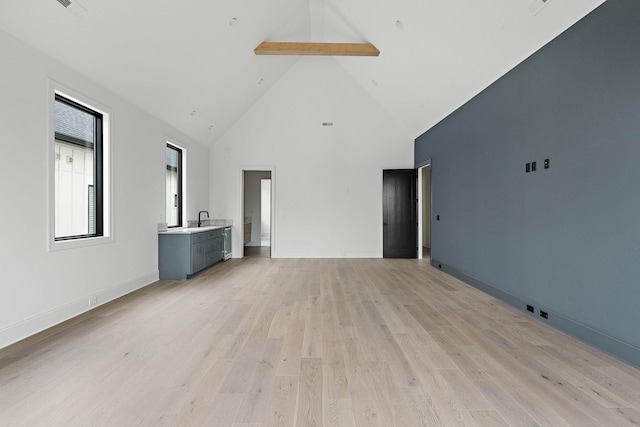 219 Chamberlin St, Nashville, TN 37209 - unfurnished living room with beam ceiling, high vaulted ceiling, light wood-style flooring, and baseboards