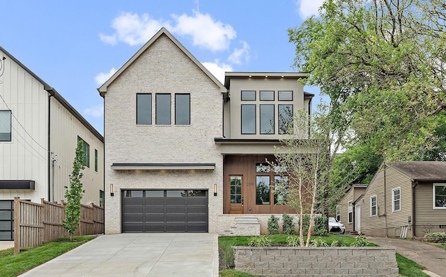 219 Chamberlin St, Nashville, TN 37209 - contemporary home with brick siding, an attached garage, fence, and concrete driveway