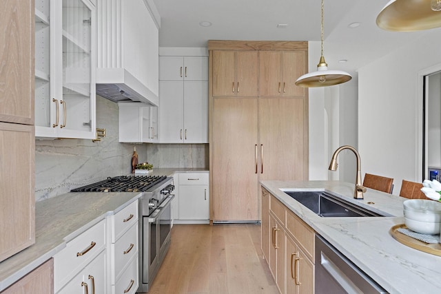 219 Chamberlin St, Nashville, TN 37209 - kitchen featuring stainless steel appliances, a sink, light stone countertops, light wood-type flooring, and backsplash