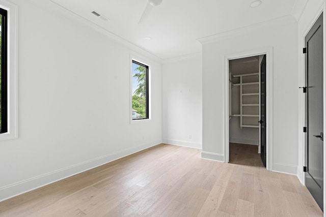 219 Chamberlin St, Nashville, TN 37209 - unfurnished bedroom featuring light wood finished floors, a spacious closet, baseboards, crown molding, and a closet