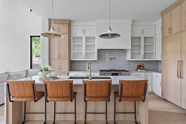 219 Chamberlin St, Nashville, TN 37209 - kitchen featuring decorative backsplash, a breakfast bar area, a sink, decorative light fixtures, and stove