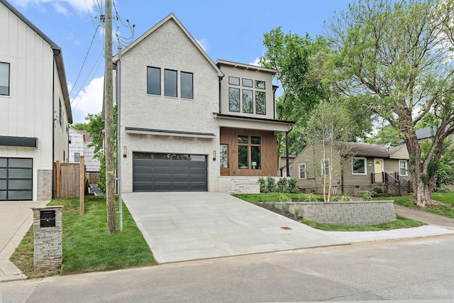 219 Chamberlin St, Nashville, TN 37209 - view of front facade featuring an attached garage, driveway, and brick siding