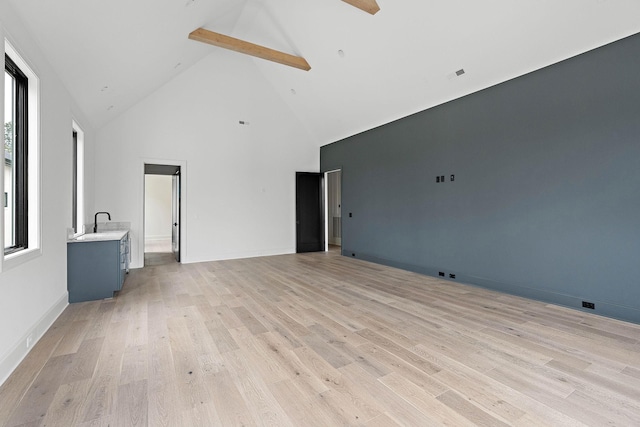 219 Chamberlin St, Nashville, TN 37209 - unfurnished living room with high vaulted ceiling, light wood finished floors, beamed ceiling, and baseboards