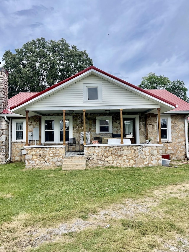 233 Shelton Dr, Saint Joseph, TN 38481 - view of front of home with stone siding, metal roof, a front lawn, and a porch