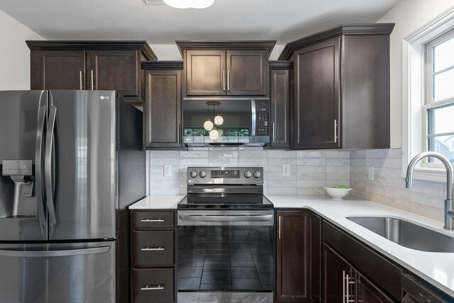1021 Charles Thomas Dr, Clarksville, TN 37042 - kitchen featuring stainless steel appliances, a sink, dark brown cabinetry, and light countertops