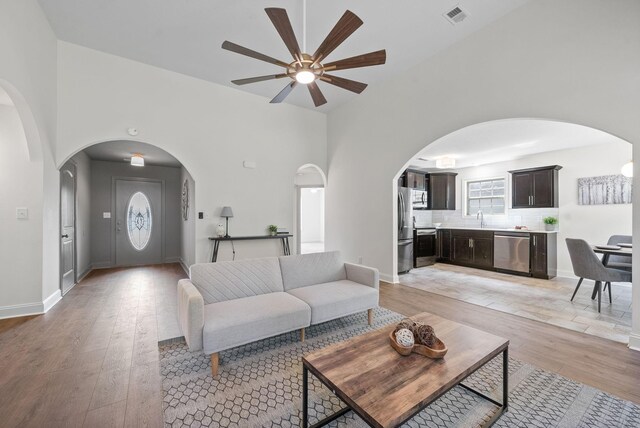 1021 Charles Thomas Dr, Clarksville, TN 37042 - living room with a ceiling fan, light wood-style floors, arched walkways, and baseboards