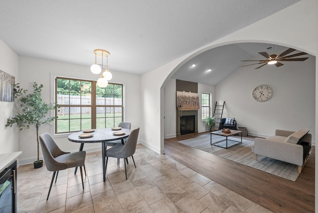 1021 Charles Thomas Dr, Clarksville, TN 37042 - dining area featuring a fireplace, baseboards, ceiling fan, lofted ceiling, and arched walkways