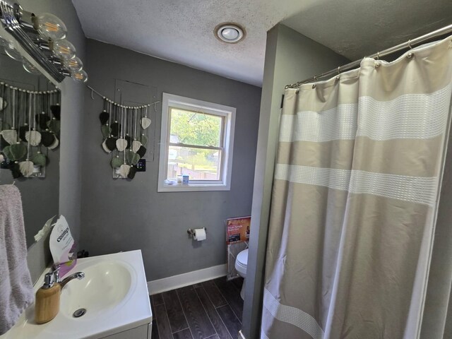 163 Bryan Ave, La Fayette, KY 42254 - full bath with baseboards, toilet, a textured ceiling, wood finish floors, and vanity