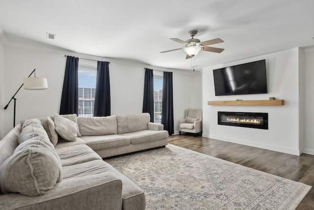 1007 Fairways Dr, Greenbrier, TN 37073 - living room with healthy amount of natural light, wood finished floors, a glass covered fireplace, a ceiling fan, and crown molding