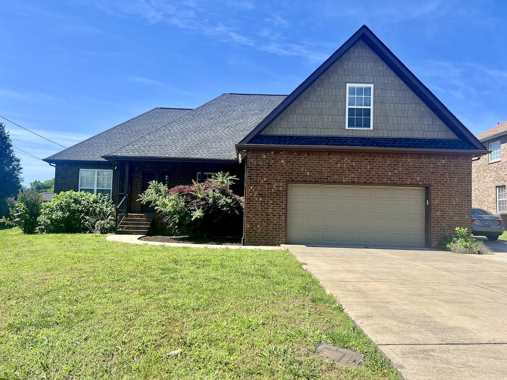 view of front of property with a front yard, driveway, and brick siding