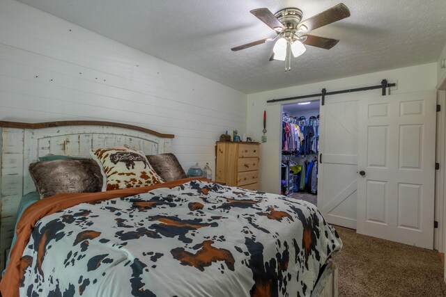 2659 Cave Springs Rd, Springfield, TN 37172 - carpeted bedroom featuring a barn door, a spacious closet, a closet, a ceiling fan, and a textured ceiling