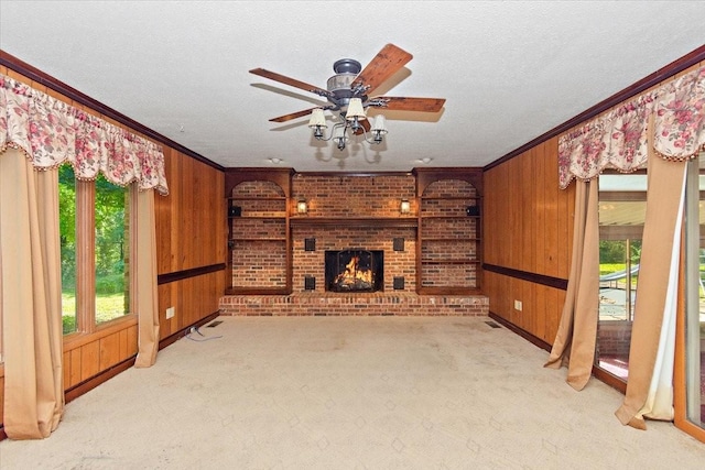 103 Colwell Ln, Manchester, TN 37355 - unfurnished living room with ornamental molding, wood walls, ceiling fan, carpet, and a brick fireplace