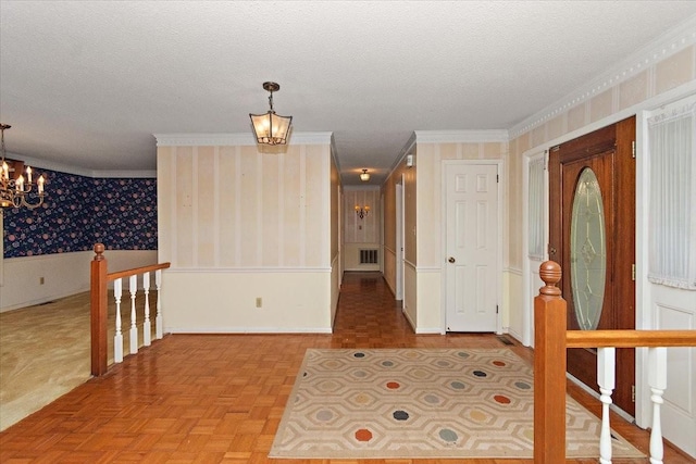 103 Colwell Ln, Manchester, TN 37355 - foyer with a chandelier, wallpapered walls, ornamental molding, a textured ceiling, and a wainscoted wall