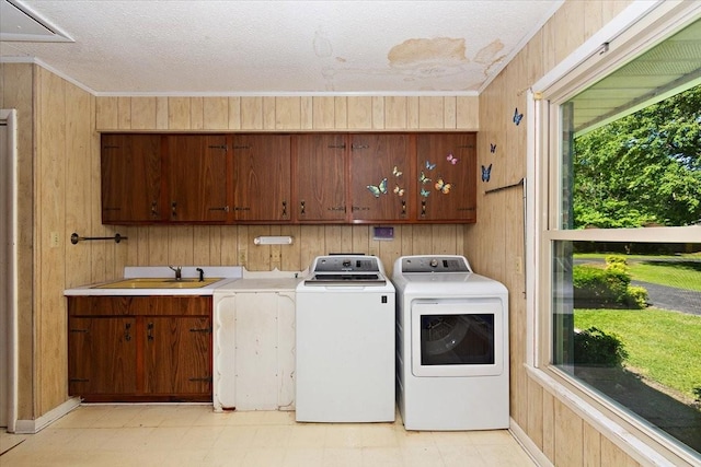 103 Colwell Ln, Manchester, TN 37355 - laundry area featuring cabinet space, washer and clothes dryer, wooden walls, light floors, and ornamental molding