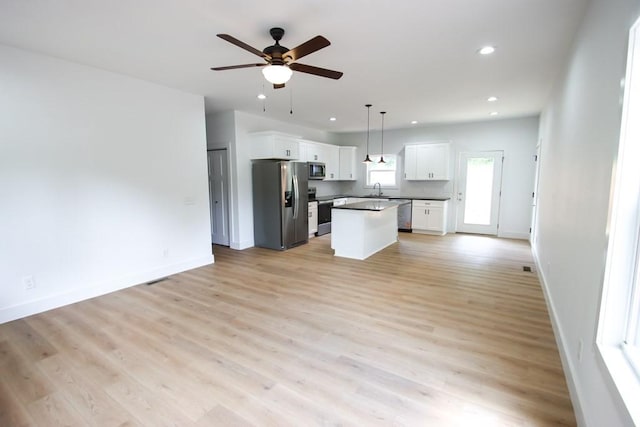 70 River Oaks Dr, Sparta, TN 38583 - kitchen featuring appliances with stainless steel finishes, open floor plan, white cabinets, a ceiling fan, and a kitchen island