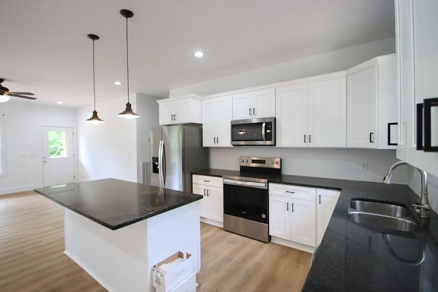 70 River Oaks Dr, Sparta, TN 38583 - kitchen featuring appliances with stainless steel finishes, light wood finished floors, a sink, white cabinetry, and recessed lighting