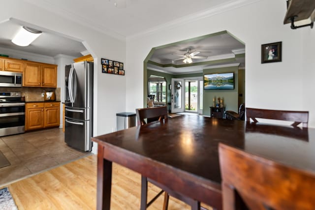 1383 Smith Chapel Rd, Shelbyville, TN 37160 - kitchen featuring stainless steel appliances, crown molding, arched walkways, brown cabinetry, and dark countertops