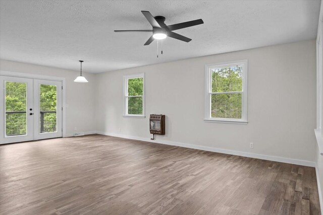 1079 Hillcrest Rd, Waverly, TN 37185 - unfurnished room with heating unit, french doors, wood finished floors, a textured ceiling, and baseboards