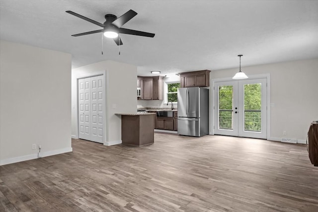1079 Hillcrest Rd, Waverly, TN 37185 - unfurnished living room with light wood-style floors, french doors, a ceiling fan, and baseboards
