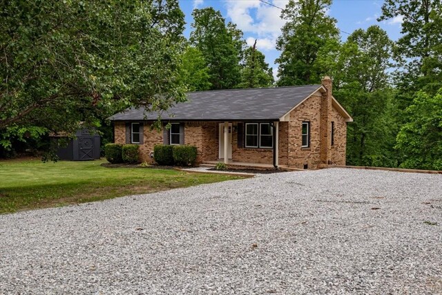 1079 Hillcrest Rd, Waverly, TN 37185 - ranch-style house with a chimney, driveway, a front lawn, a porch, and a shed