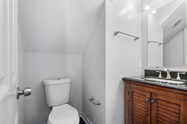 517 Eversholt Ct, Antioch, TN 37013 - bathroom with vaulted ceiling, toilet, vanity, and a textured ceiling