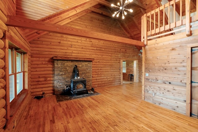 1794 Mosley Ferry Rd, Chapmansboro, TN 37035 - unfurnished living room featuring a chandelier, wood-type flooring, a wood stove, high vaulted ceiling, and wood ceiling with exposed beams