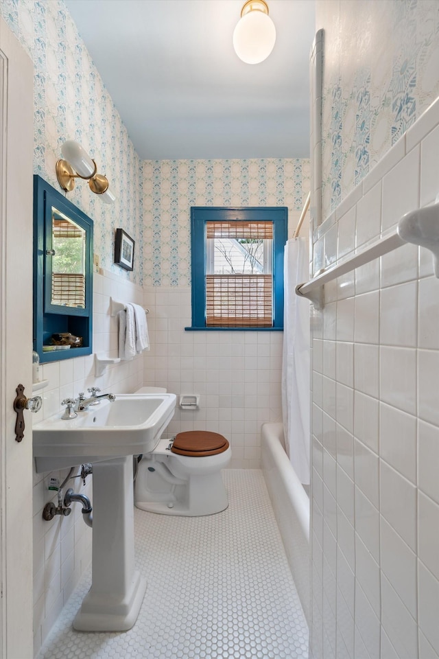 2209 Natchez Trce, Nashville, TN 37212 - bathroom featuring tile walls, wallpapered walls, toilet, wainscoting, and tile patterned flooring