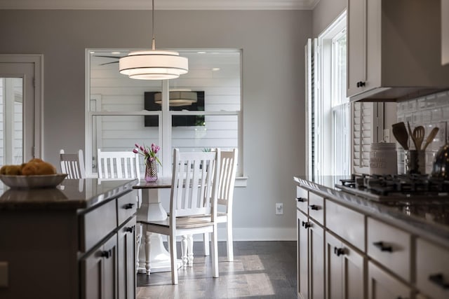 2060 Bushnell Farm Dr, Franklin, TN 37064 - kitchen with baseboards, crown molding, gas cooktop, dark countertops, and decorative light fixtures