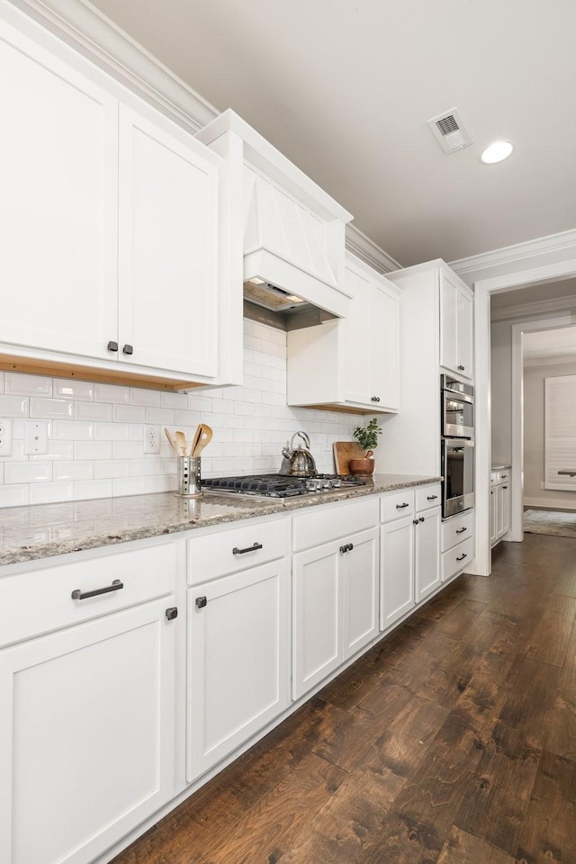 2060 Bushnell Farm Dr, Franklin, TN 37064 - kitchen featuring appliances with stainless steel finishes, dark wood finished floors, decorative backsplash, white cabinets, and crown molding
