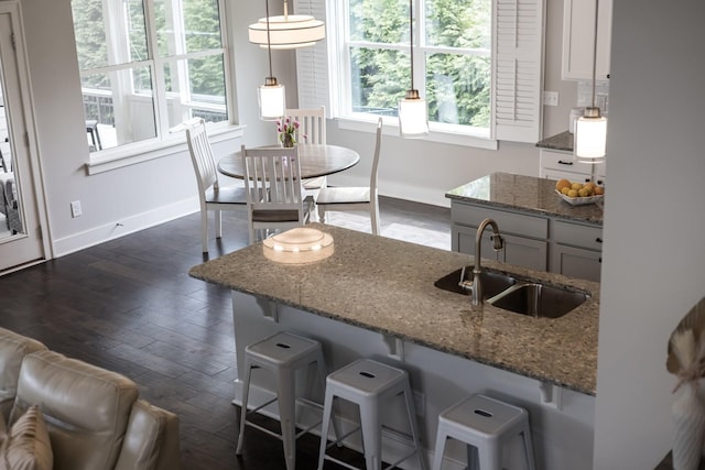 2060 Bushnell Farm Dr, Franklin, TN 37064 - kitchen featuring a sink, dark stone counters, a kitchen bar, and baseboards