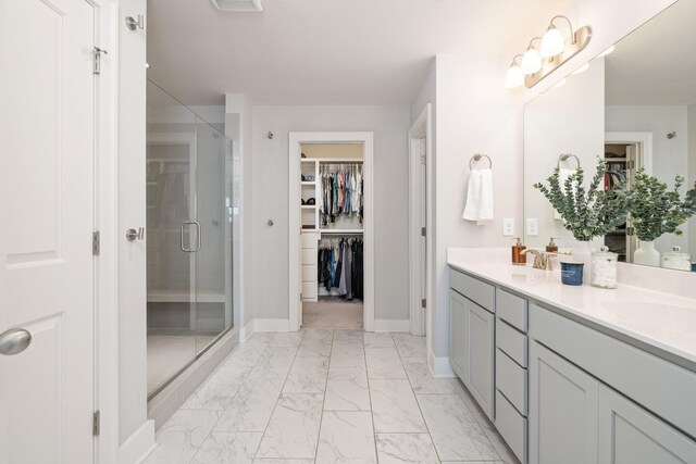 2060 Bushnell Farm Dr, Franklin, TN 37064 - bathroom featuring marble look tile flooring, double vanity, a walk in closet, and a shower stall