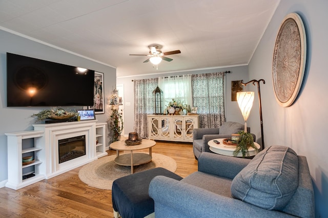 470 Arlington St, Erin, TN 37061 - living area with crown molding, ceiling fan, wood finished floors, and a glass covered fireplace